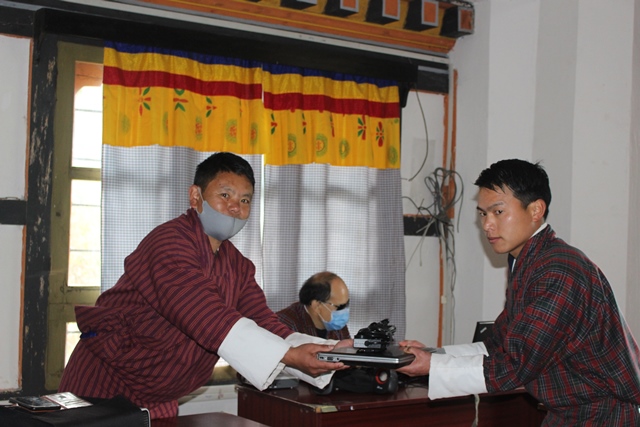 photo: Phuntsho Wangdi receiving laptop.